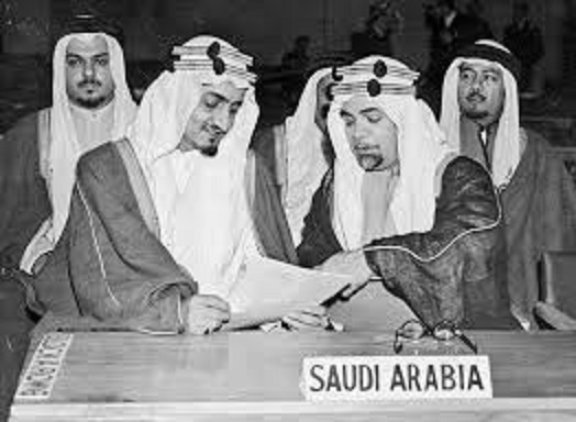 حافظ وهبة " يمينا " والملك الراحل فيصل بن سعود يتدراسان وثيقة في أحدى المؤتمرات 