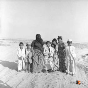 سيدة من البادية في احضان الصحراء مع ابناءها في صورة جماعية