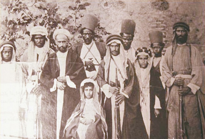 عبدالله السالم جالسا على الكرسي- بينما يظهر عمه حمد المبارك الثالث من اليمين ، التقطت الصورة في المحمرة في ضيافة الشيخ خزعل 1908 ( الراي )