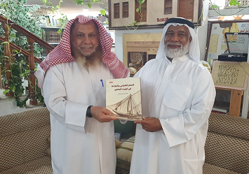 الباحث فؤاد بوعركي "يمينا " يهدي الدكتور محمد بن إبراهيم الشيباني كتابه عن السفر الشراعي والملاحة في كويت الماضي