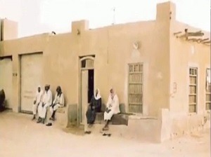 أحد بيوت أهالي قرية حليفة قديما ويظهر فيها الأهالي متجمعون على الدكة .