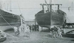 عمال ينقلون قرب الماء من مراكب جلبتها من شط العرب للكويت