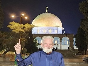 الداعية الأمريكي صموئيل شروبشاير ويبدو المسجد الأقصى في الصورة