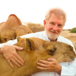 القس السابق والداعية الإسلامي الأمريكي صموئيل شروبشاير يظهر رأفة الإسلام بالحيوان باحنضانه جمل في السعودية