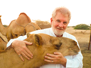 القس السابق والداعية الإسلامي الأمريكي صموئيل شروبشاير يظهر رأفة الإسلام بالحيوان باحنضانه جمل في السعودية 